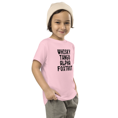 "Whisky Tango Alpha Foxtrot" printed on a pink toddler short sleeve tee worn by a male who is also wearing a knit cap