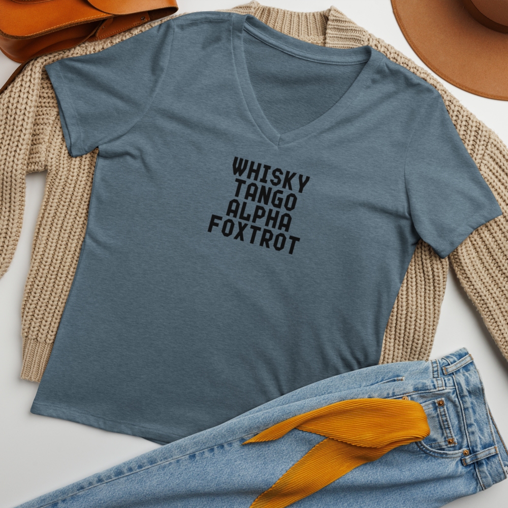 "Whisky Tango Alpha Foxtrot" printed on a heather slate women's relaxed v-neck t-shirt laying on a flat surface amongst other clothes