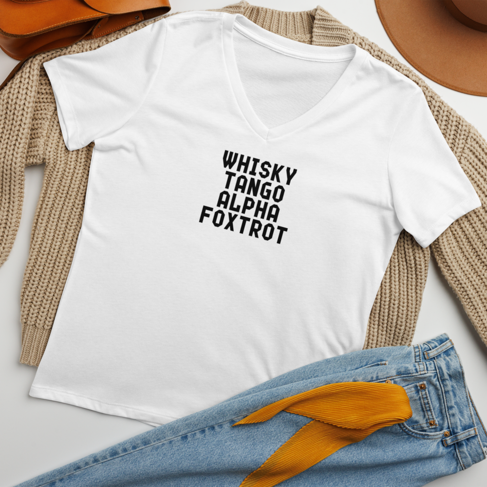 "Whisky Tango Alpha Foxtrot" printed on a solid white blend women's relaxed v-neck t-shirt laying on a flat surface amongst other clothes