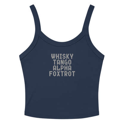 "Whisky Tango Alpha Foxtrot" printed on a solid navy blend women's micro-rib tanktop laying on a flat surface amongst sunglasses and shorts