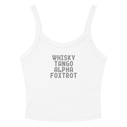 "Whisky Tango Alpha Foxtrot" printed on a solid white blend women's micro-rib tanktop laying on a flat surface amongst sunglasses and shorts