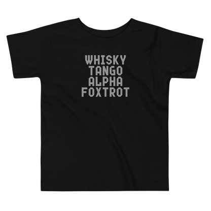 "Whisky Tango Alpha Foxtrot" printed on a black toddler short sleeve tee laying on a flat surface