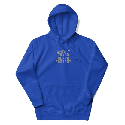 "Whisky Tango Alpha Foxtrot" printed on a team royal unisex hoodie laying on a flat surface with the hood up