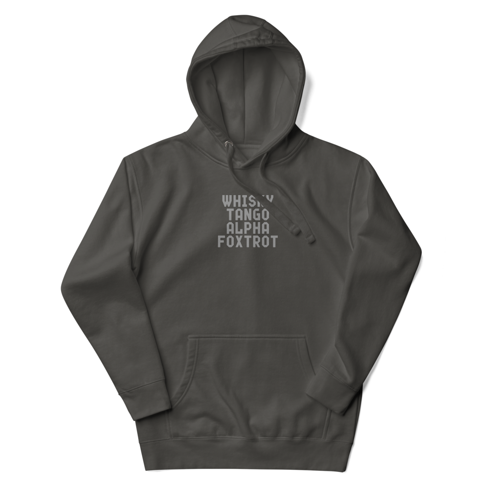 "Whisky Tango Alpha Foxtrot" printed on a vintage black unisex hoodie laying on a flat surface with the hood up