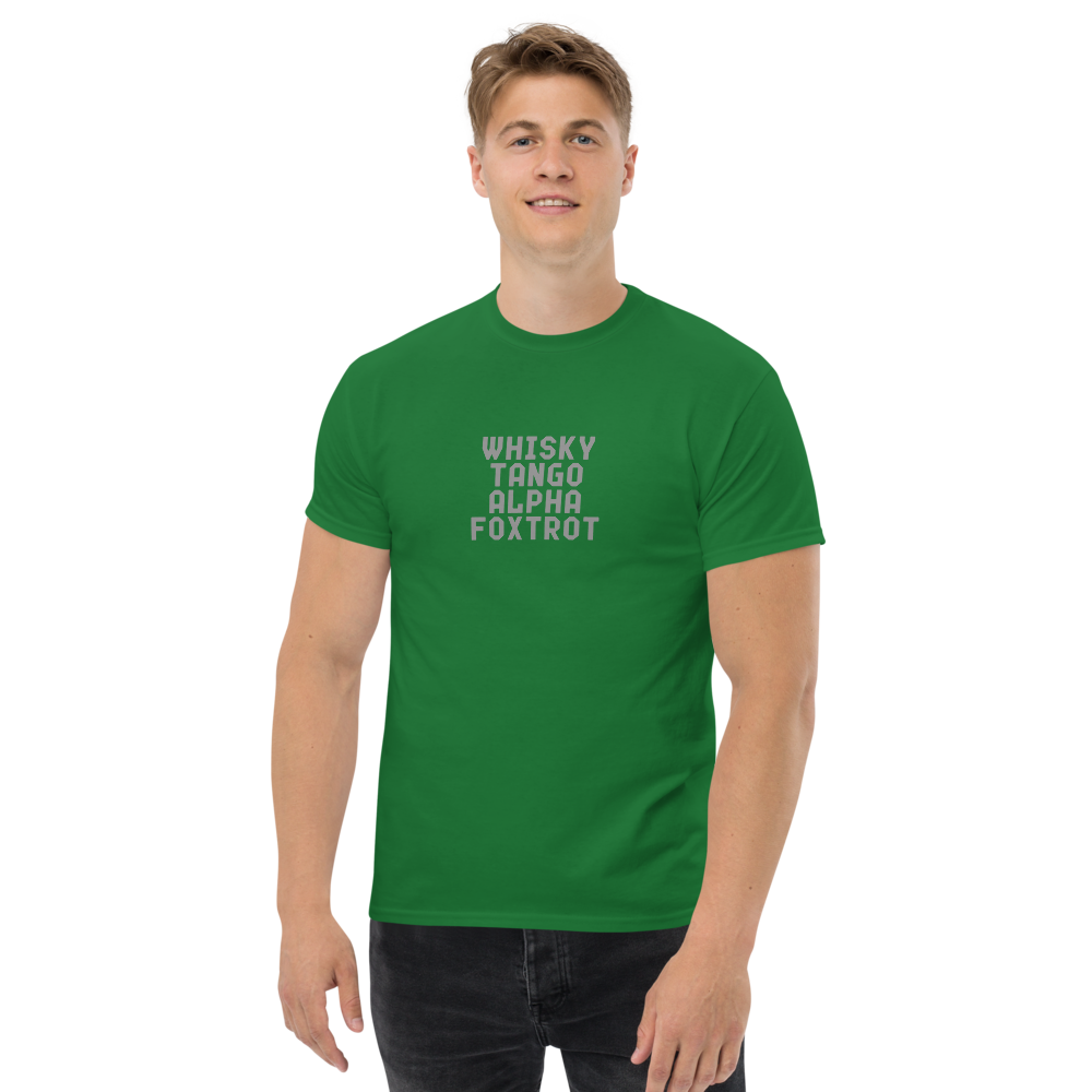 "Whisky Tango Alpha Foxtrot" printed on a turf green unisex classic tee worn by a male