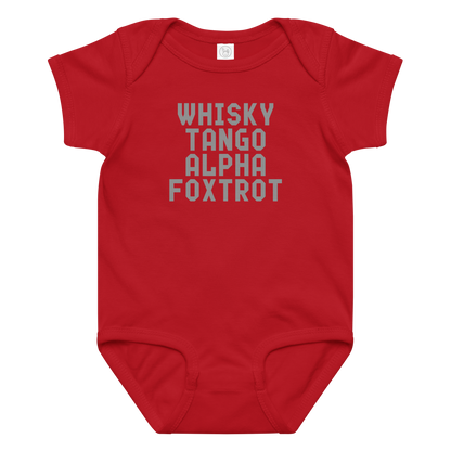 "Whisky Tango Alpha Foxtrot" printed on a red baby jersey bodysuit laying on a flat surface amongst other clothes