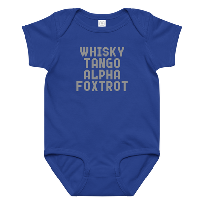 "Whisky Tango Alpha Foxtrot" printed on a royal baby jersey bodysuit laying on a flat surface amongst other clothes
