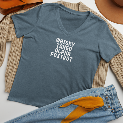 "Whisky Tango Alpha Foxtrot" printed on a heather slate women's relaxed v-neck t-shirt laying on a flat surface amongst other clothes