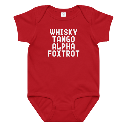 "Whisky Tango Alpha Foxtrot" printed on a red baby jersey bodysuit laying on a flat surface amongst other clothes
