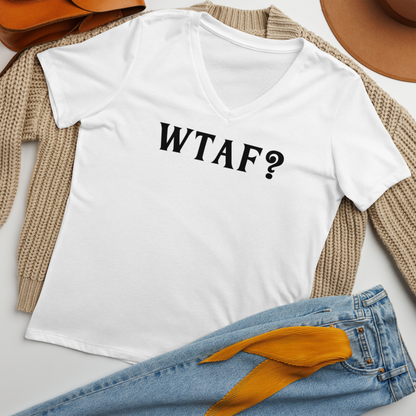 "WTAF?" printed on a solid white blend women's relaxed v-neck t-shirt laying on a flat surface amongst other clothes