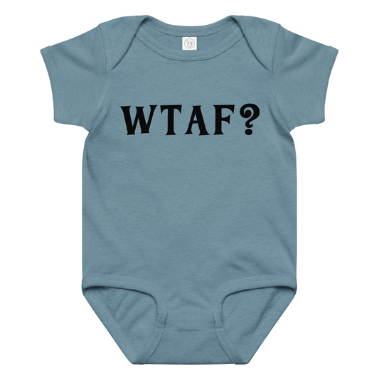 "WTAF?" printed on a vintage indigo baby jersey bodysuit laying on a flat surface amongst other clothes