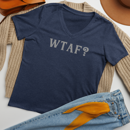 "WTAF?" printed on a heather navy women's relaxed v-neck t-shirt laying on a flat surface amongst other clothes