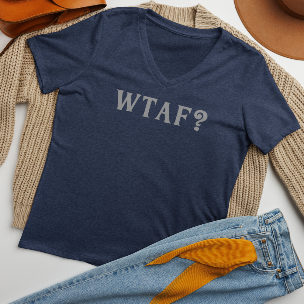 "WTAF?" printed on a heather navy women's relaxed v-neck t-shirt laying on a flat surface amongst other clothes
