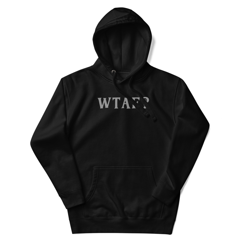 "WTAF?" printed on a black unisex hoodie laying on a flat surface with the hood up