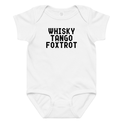 "Whisky Tango Foxtrot (What the f#ck)" printed on a white baby jersey bodysuit laying on a flat surface amongst other clothes