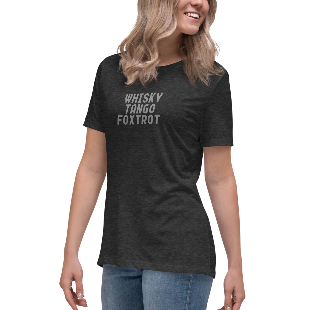 "Whisky Tango Foxtrot (What the f#ck)" printed on a dark grey heather women's relaxed t-shirt worn by a female