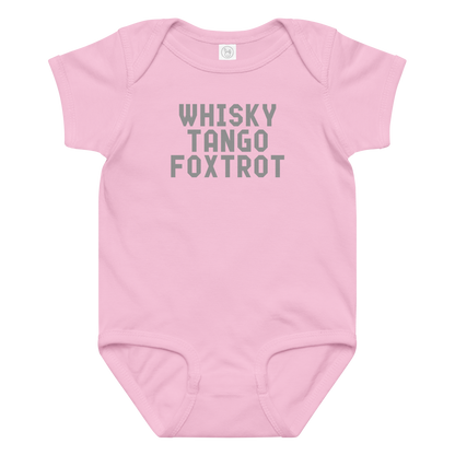"Whisky Tango Foxtrot (What the f#ck)" printed on a pink baby jersey bodysuit laying on a flat surface amongst other clothes