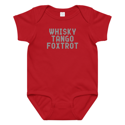 "Whisky Tango Foxtrot (What the f#ck)" printed on a red baby jersey bodysuit laying on a flat surface amongst other clothes