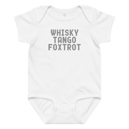 "Whisky Tango Foxtrot (What the f#ck)" printed on a white baby jersey bodysuit laying on a flat surface amongst other clothes