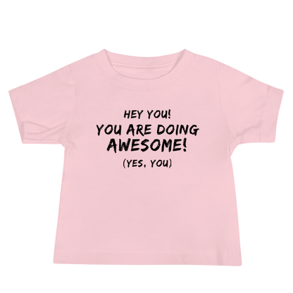 "Hey You! You are doing awesome! (Yes, you)" printed on a pink baby jersey short sleeve tee laying on a flat surface