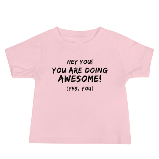 "Hey You! You are doing awesome! (Yes, you)" printed on a pink baby jersey short sleeve tee laying on a flat surface