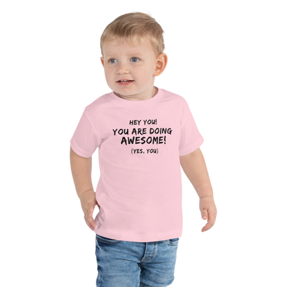 "Hey You! You are doing awesome! (Yes, you)" printed on a pink toddler short sleeve tee worn by a male