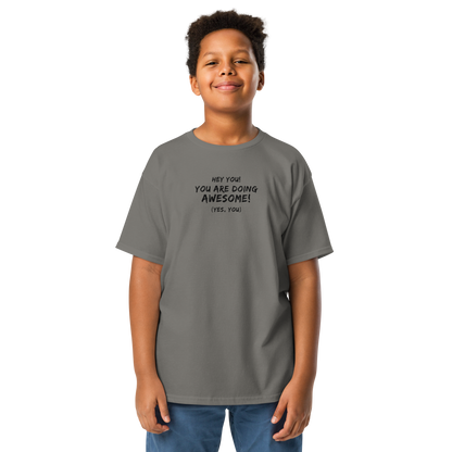 "Hey You! You are doing awesome! (Yes, you)" printed on a charcoal youth classic tee worn by a male