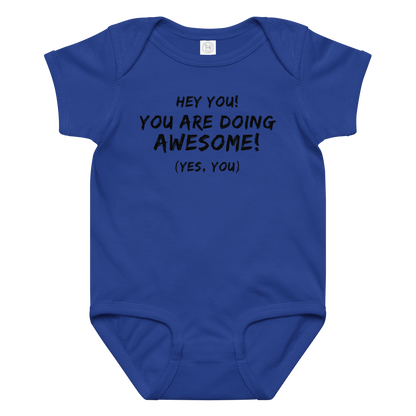 "Hey You! You are doing awesome! (Yes, you)" printed on a royal baby jersey bodysuit laying on a flat surface amongst other clothes