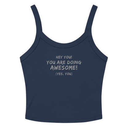 "Hey You! You are doing awesome! (Yes, you)" printed on a solid navy blend women's micro-rib tanktop laying on a flat surface amongst sunglasses and shorts