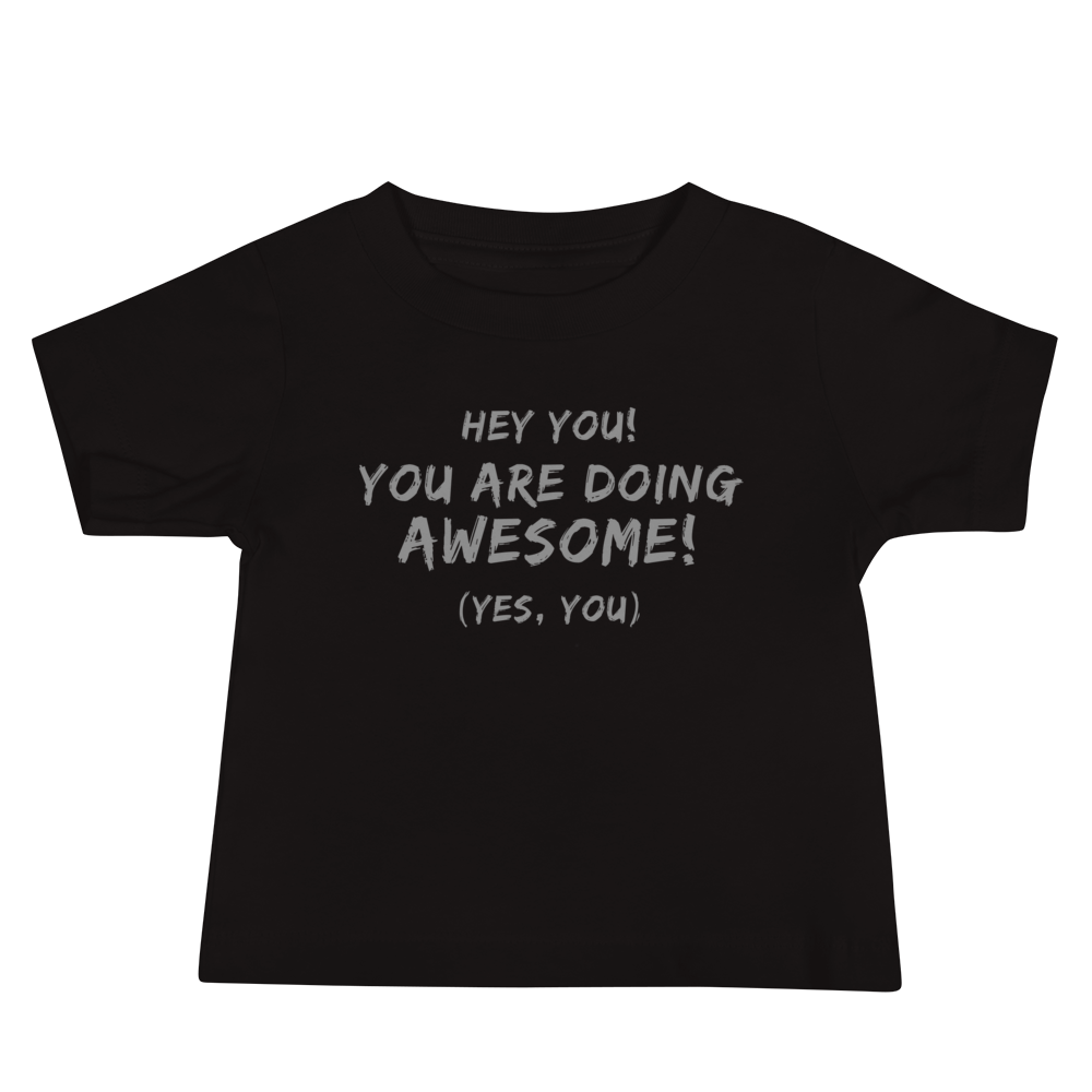 "Hey You! You are doing awesome! (Yes, you)" printed on a black baby jersey short sleeve tee laying on a flat surface