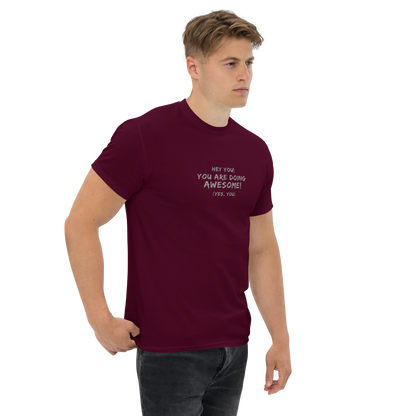 "Hey You! You are doing awesome! (Yes, you)" printed on a maroon unisex classic tee worn by a male