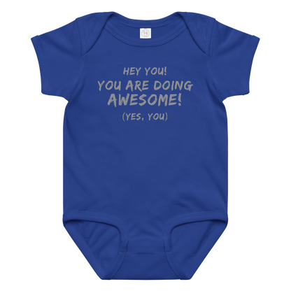 "Hey You! You are doing awesome! (Yes, you)" printed on a royal baby jersey bodysuit laying on a flat surface amongst other clothes