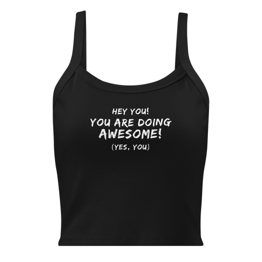 "Hey You! You are doing awesome! (Yes, you)" printed on a solid black blend women's micro-rib tanktop laying on a flat surface