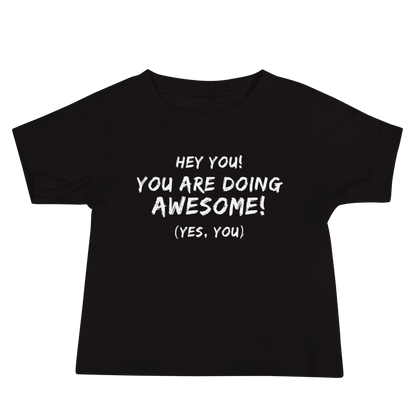 "Hey You! You are doing awesome! (Yes, you)" printed on a black baby jersey short sleeve tee laying on a flat surface