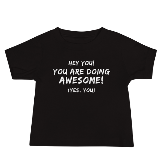 "Hey You! You are doing awesome! (Yes, you)" printed on a black baby jersey short sleeve tee laying on a flat surface