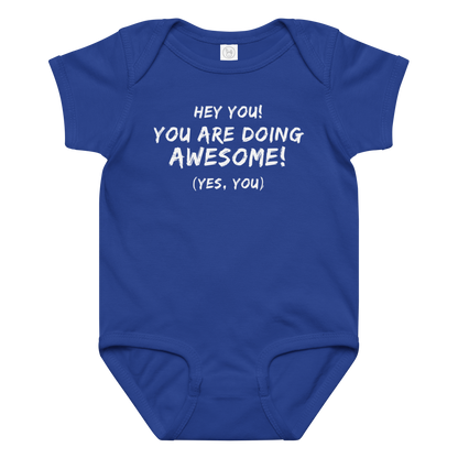 "Hey You! You are doing awesome! (Yes, you)" printed on a royal baby jersey bodysuit laying on a flat surface amongst other clothes