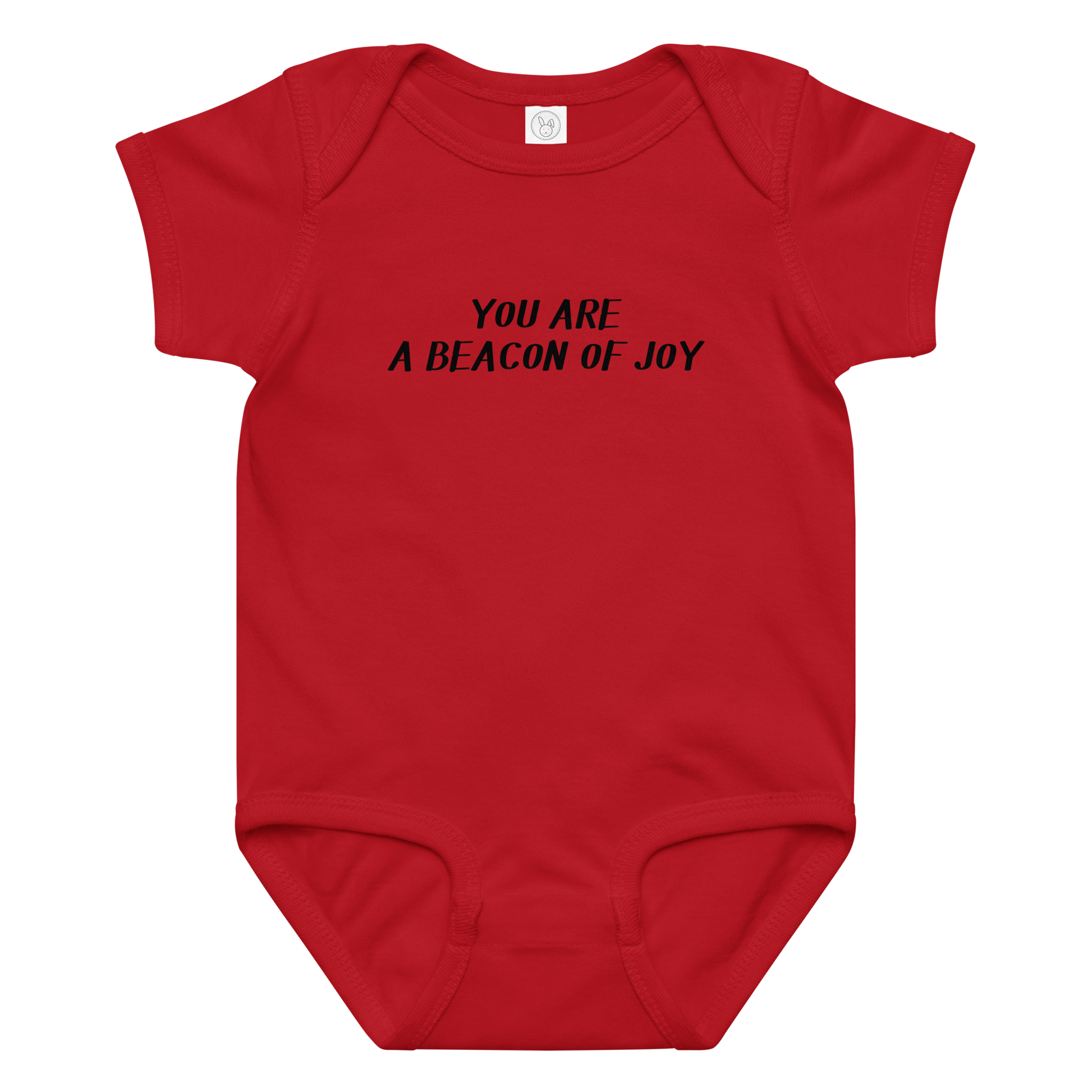 "You are a beacon of joy" printed on a red baby jersey bodysuit laying on a flat surface amongst other clothes