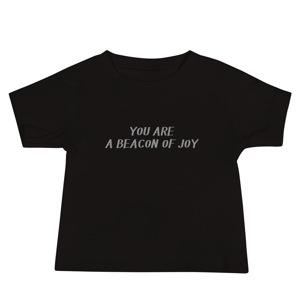 "You are a beacon of joy" printed on a black baby jersey short sleeve tee laying on a flat surface