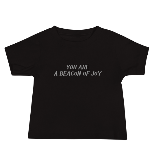 "You are a beacon of joy" printed on a black baby jersey short sleeve tee laying on a flat surface
