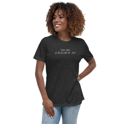 "You are a beacon of joy" printed on a dark grey heather women's relaxed t-shirt worn by a female