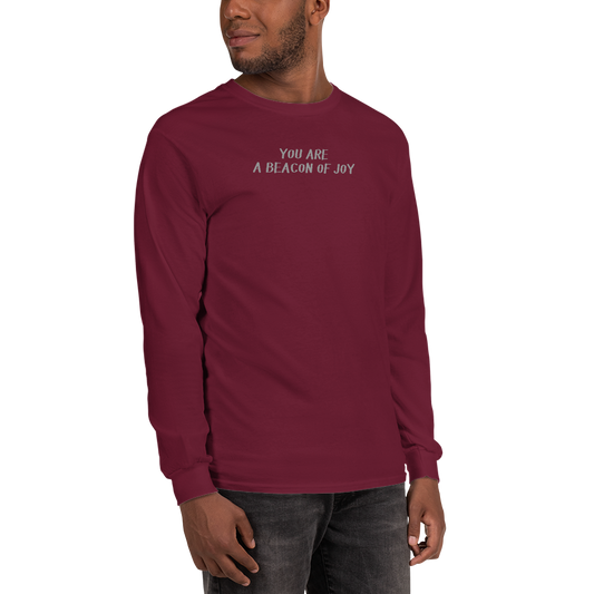 "You are a beacon of joy" printed on a maroon men's long sleeve shirt worn by a male