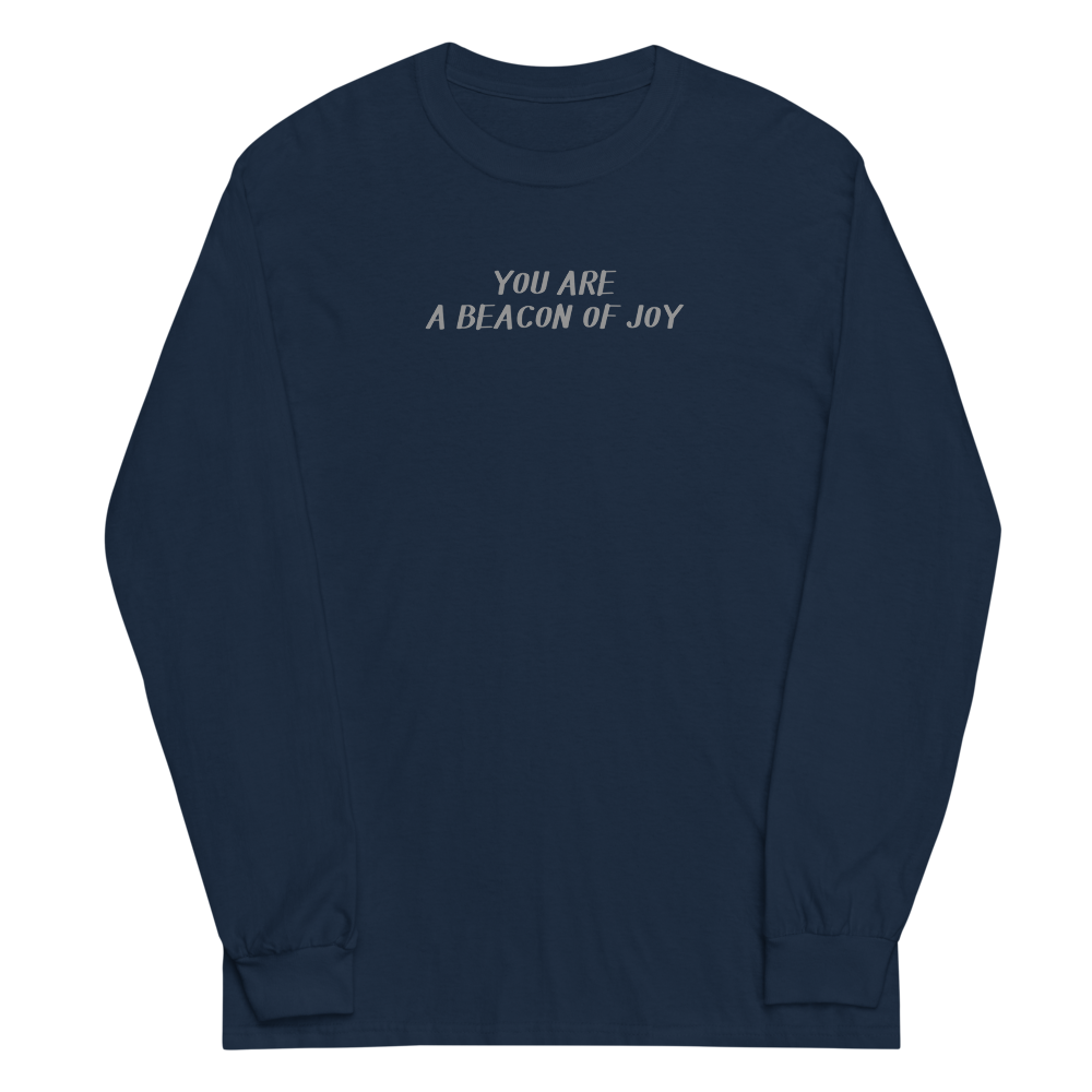 "You are a beacon of joy" printed on a navy men's long sleeve shirt laying on a flat surface