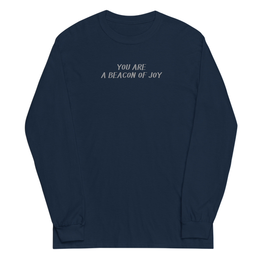"You are a beacon of joy" printed on a navy men's long sleeve shirt laying on a flat surface