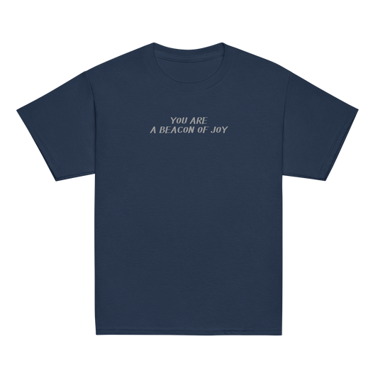"You are a beacon of joy" printed on a navy youth classic tee laying on a flat surface