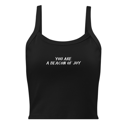 "You are a beacon of joy" printed on a solid black blend women's micro-rib tanktop laying on a flat surface