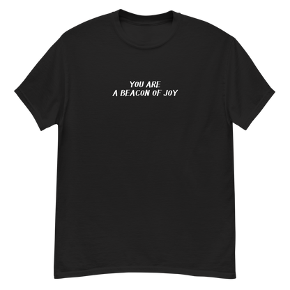"You are a beacon of joy" printed on a black unisex classic tee laying on a flat surface