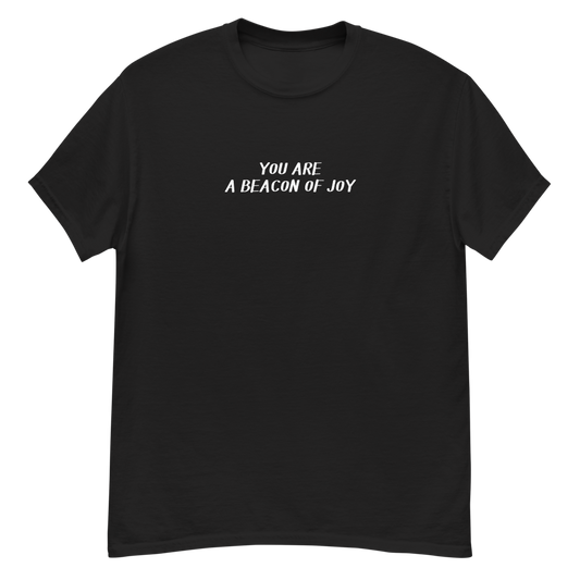 "You are a beacon of joy" printed on a black unisex classic tee laying on a flat surface