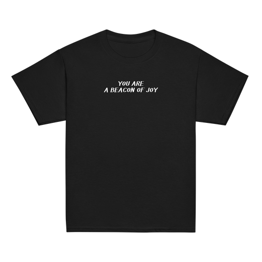 "You are a beacon of joy" printed on a black youth classic tee laying on a flat surface