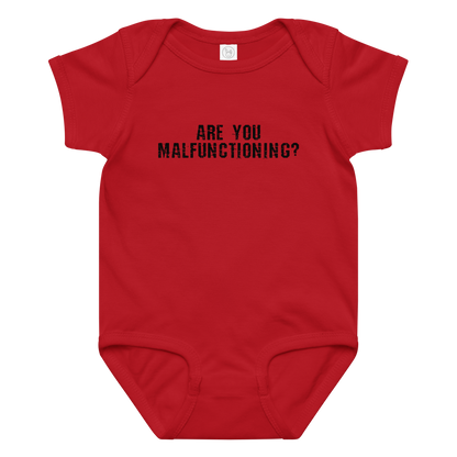 "Are you malfunctioning?" printed on a red baby jersey bodysuit laying on a flat surface amongst other clothes