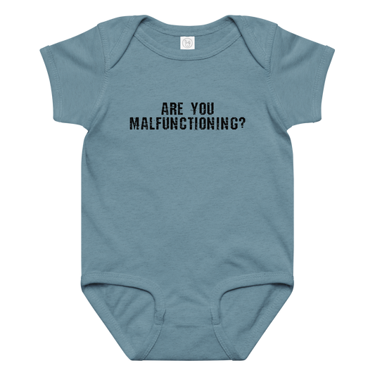 "Are you malfunctioning?" printed on a vintage indigo baby jersey bodysuit laying on a flat surface amongst other clothes